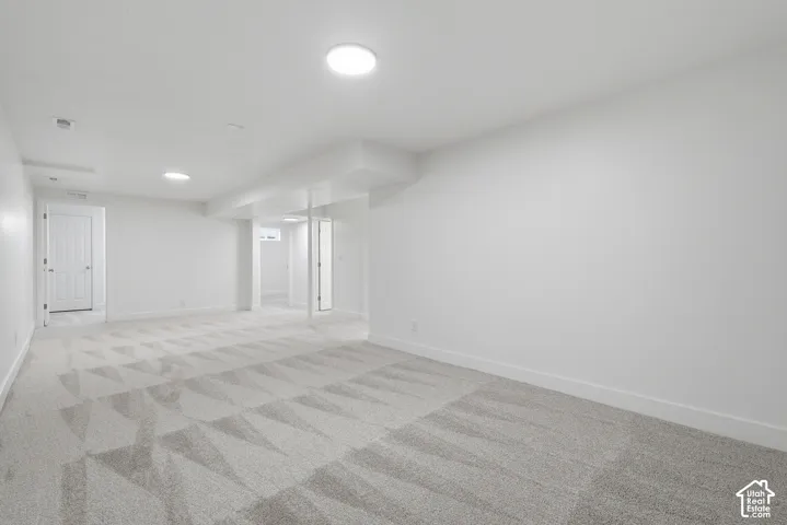 Open-concept room featuring neutral wall-to-wall carpeting, recessed ceiling lighting, and multiple interior doorways