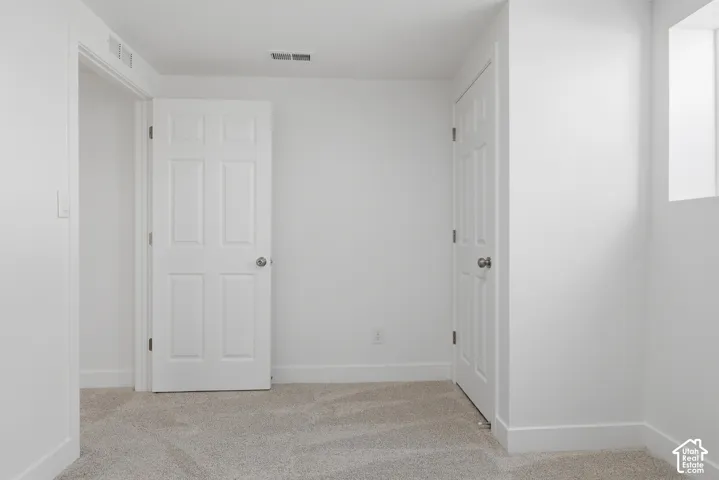 Neutral-toned carpeting, two interior six-panel doors with metallic hardware, and an recessed window