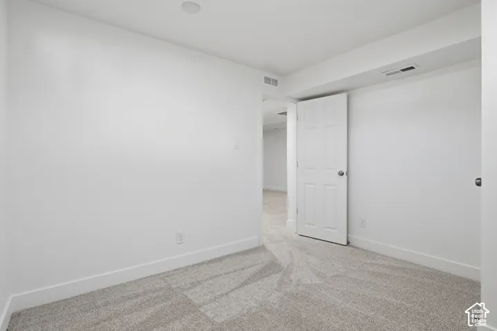 Neutral-toned wall-to-wall carpeting and a traditional six-panel interior door
