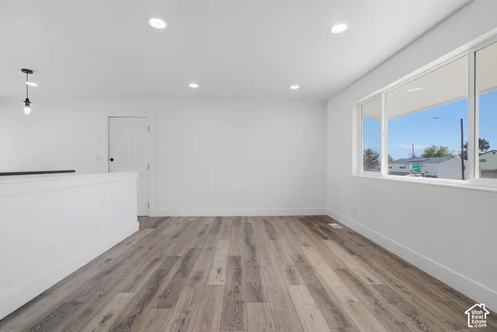 Interior space featuring wood-finish flooring, recessed lighting, a multi-panel door, and large picture windows