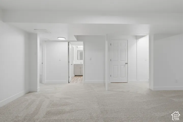 Neutral-toned wall-to-wall carpeting, crisp white walls, flush-mount lighting, and solid-core interior doors
