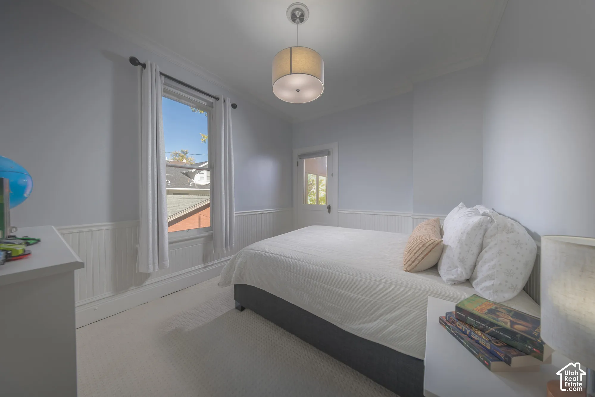 Beadboard wainscoting, neutral wall-to-wall carpeting, single-pane window, flush-mount drum pendant lighting, and a glass-panel exterior door