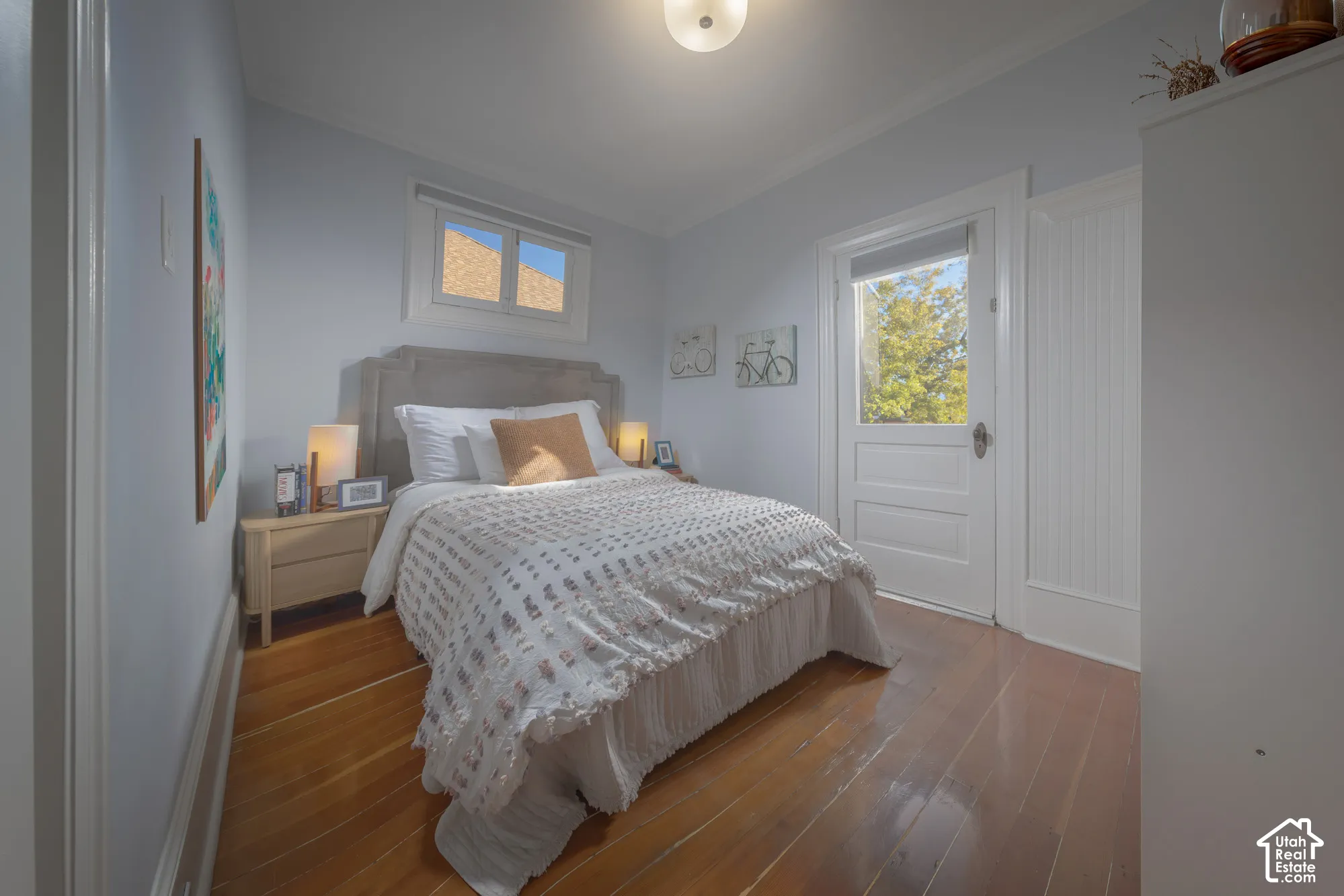Wood-finish flooring, crisp crown molding, beadboard paneling, and a private exterior door featuring a glass inset