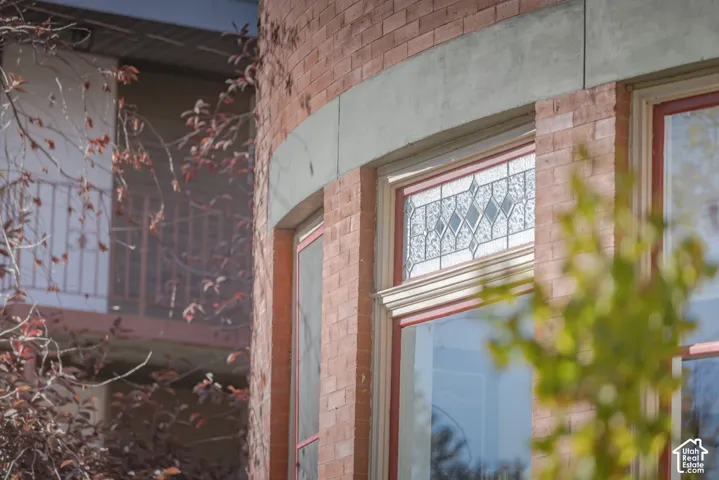 Curved exterior brick masonry featuring decorative leaded glass transom windows and stone lintel accents