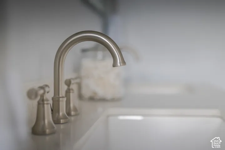 Brushed nickel widespread faucet featuring dual lever handles and a high-arc spout, paired with a white integrated basin and solid-surface countertop