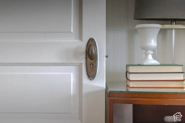 Painted wood paneled door featuring a vintage-style oval metal escutcheon plate and integrated keyhole