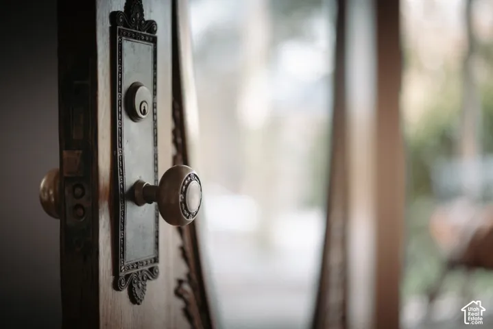 Solid wood door featuring intricate carved detailing and a vintage-style decorative metal door plate with a matching circular knob