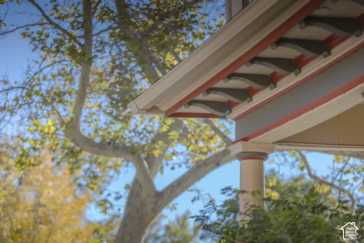 Exterior architectural details featuring decorative roof corbels, a column with a flared capital, and multi-tone painted trim