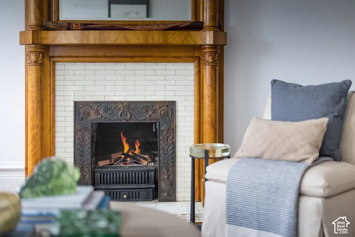 Ornate wooden fireplace mantel with decorative carved columns, integrated mirror, subway-style tile surround, and an intricate metal firebox insert
