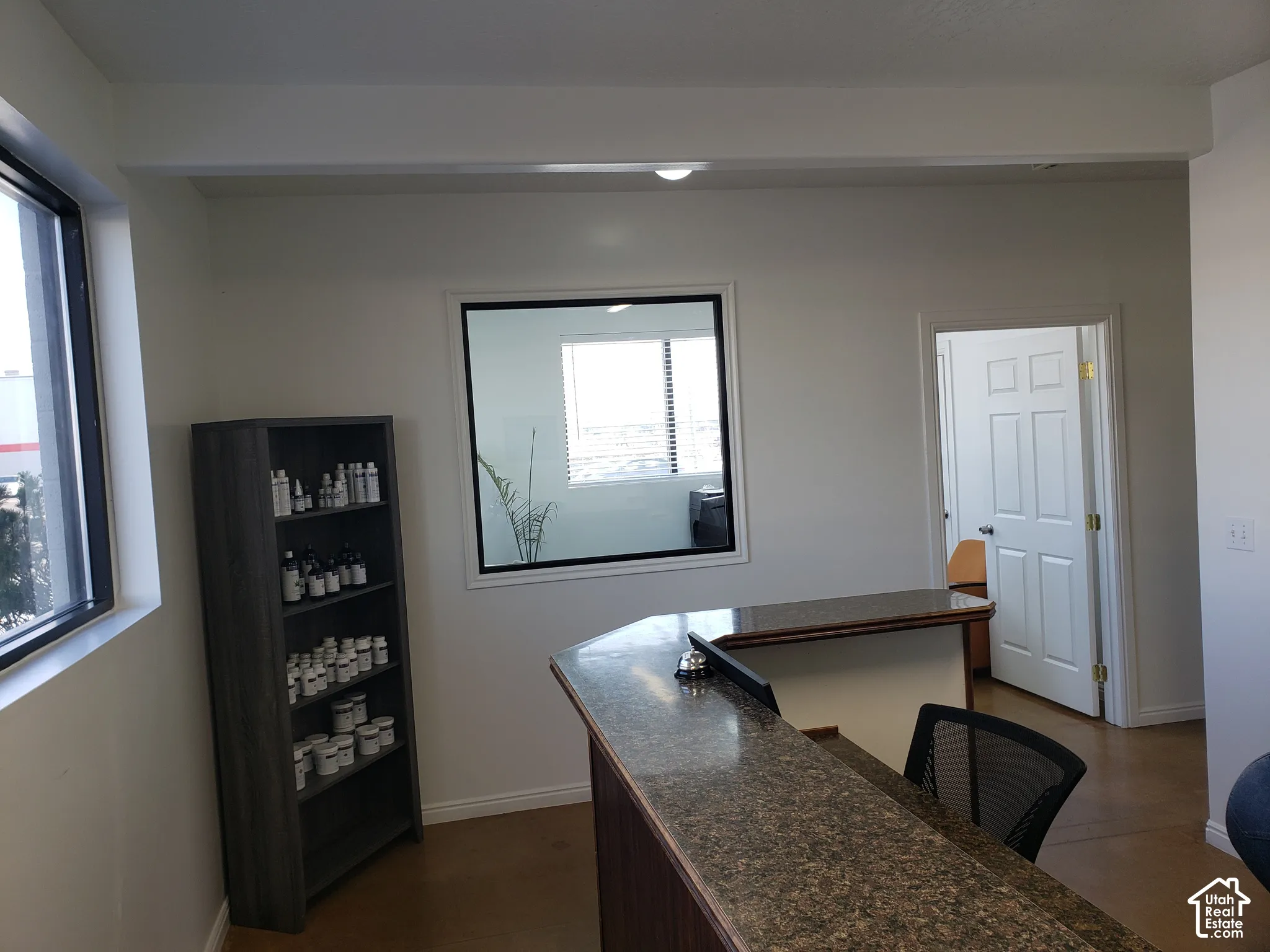 Built-in reception desk featuring a stone-finish countertop, interior window partition, and six-panel door