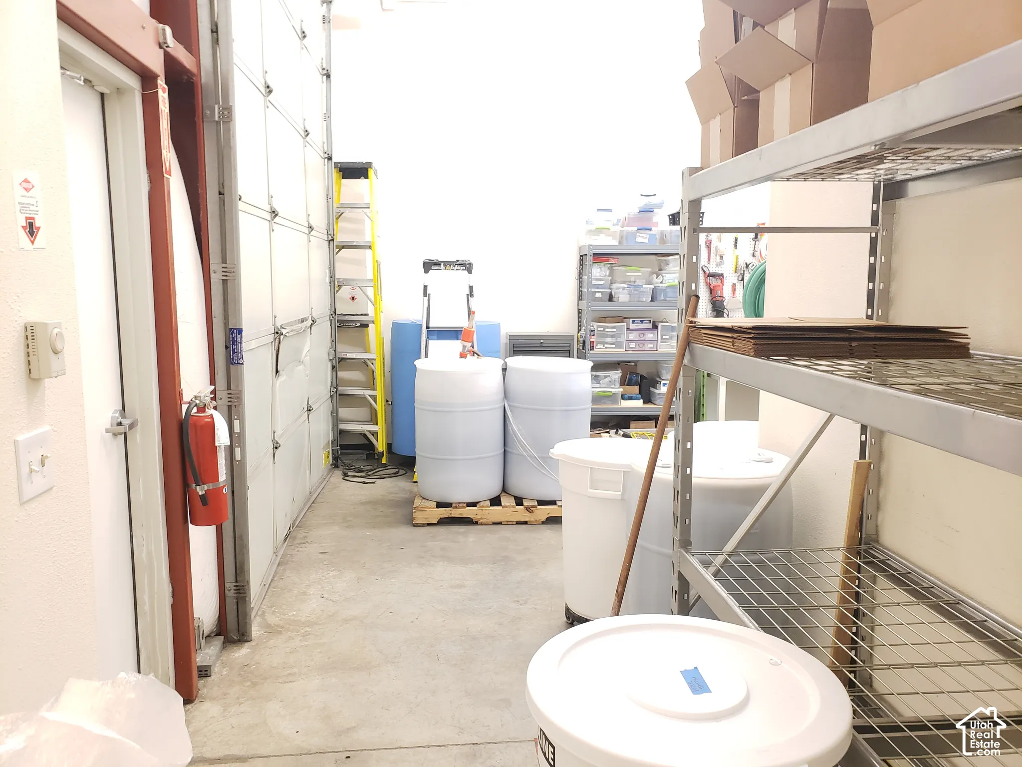 Service area featuring a roll-up bay door, concrete flooring, and an integrated fire suppression system