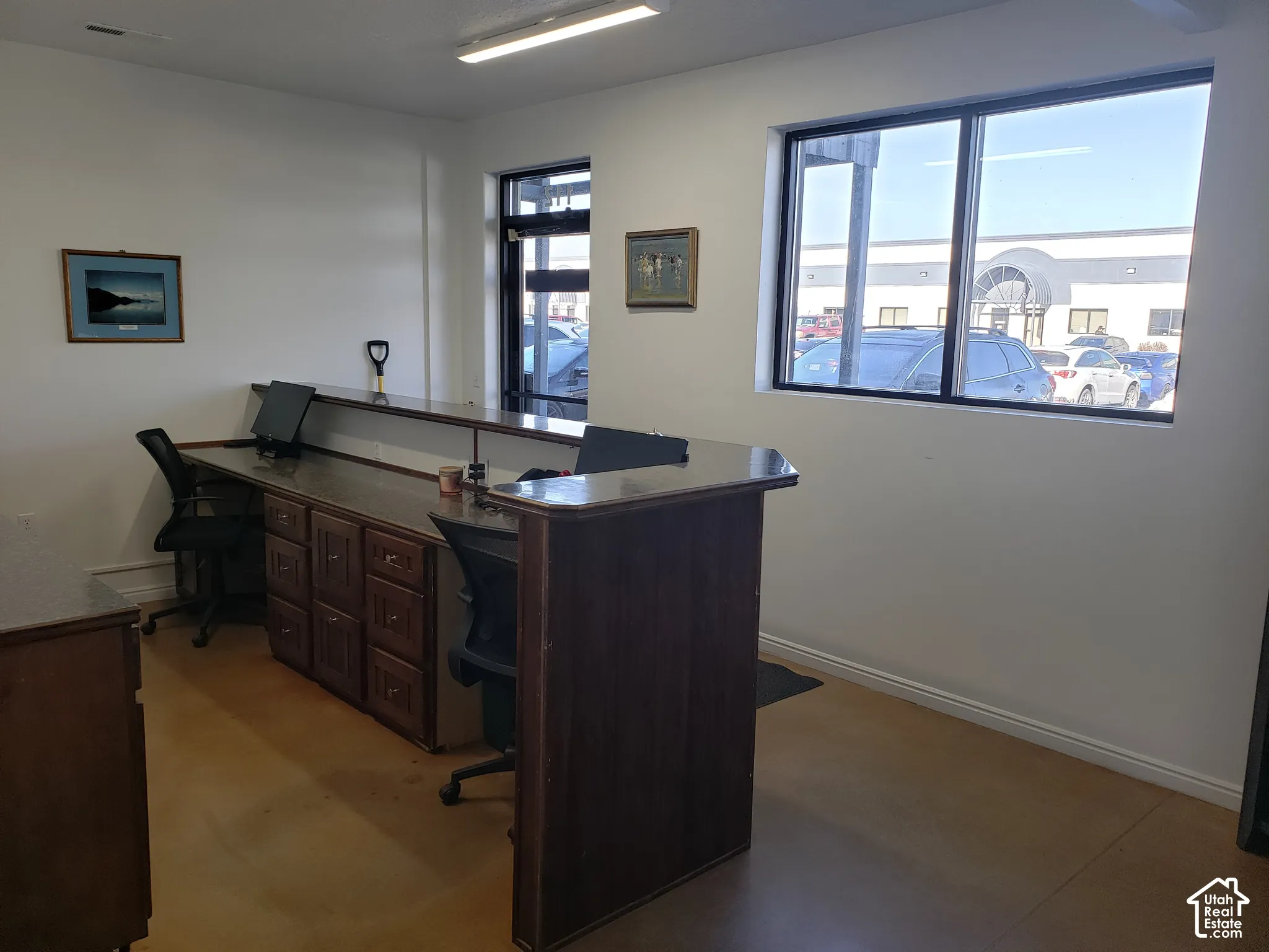 Built-in service counter with integrated cabinetry, large windows, and smooth-finish concrete flooring
