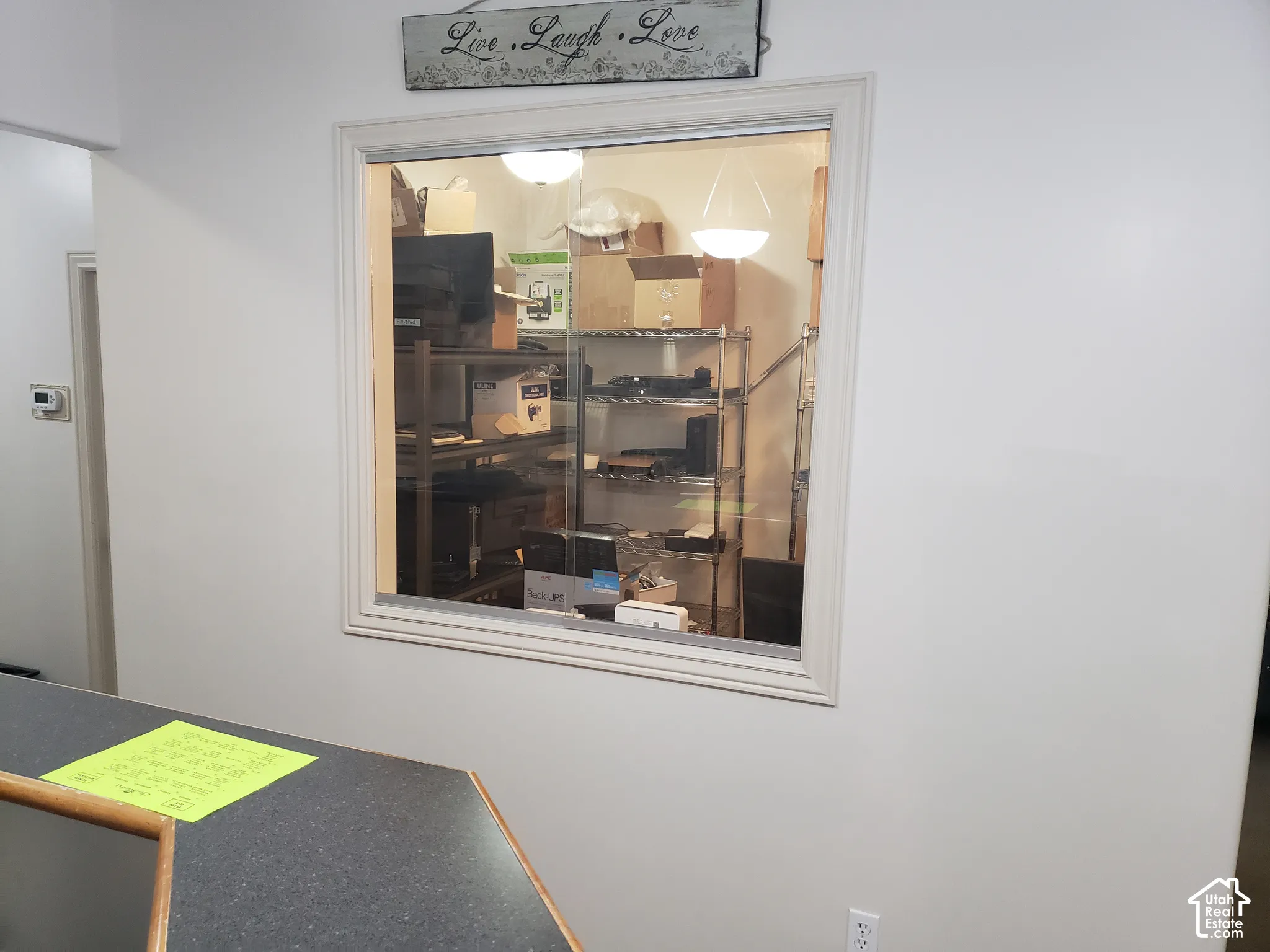 Interior sliding window with white trim frame and dark, matte-finish countertop