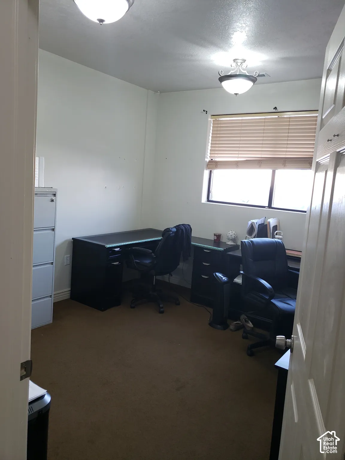 Room featuring carpeting, a single-pane window with horizontal blinds, and dual flush-mount light fixtures