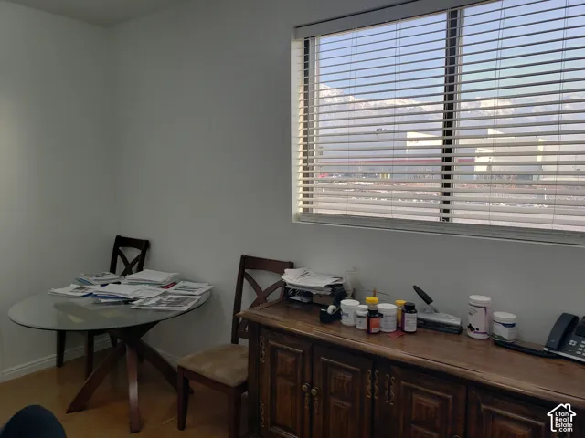 Neutral wall finish, wood-finish flooring, and a large window featuring horizontal blinds with mountain scenery