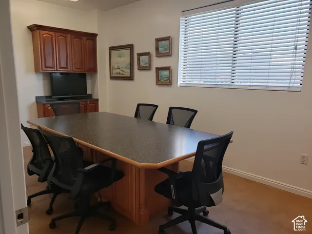 Built-in wood cabinetry with stone-surface countertop, integrated window blinds, and concrete flooring