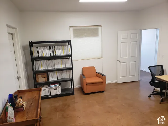 Interior room featuring polished concrete flooring, white walls, and two six-panel swing doors