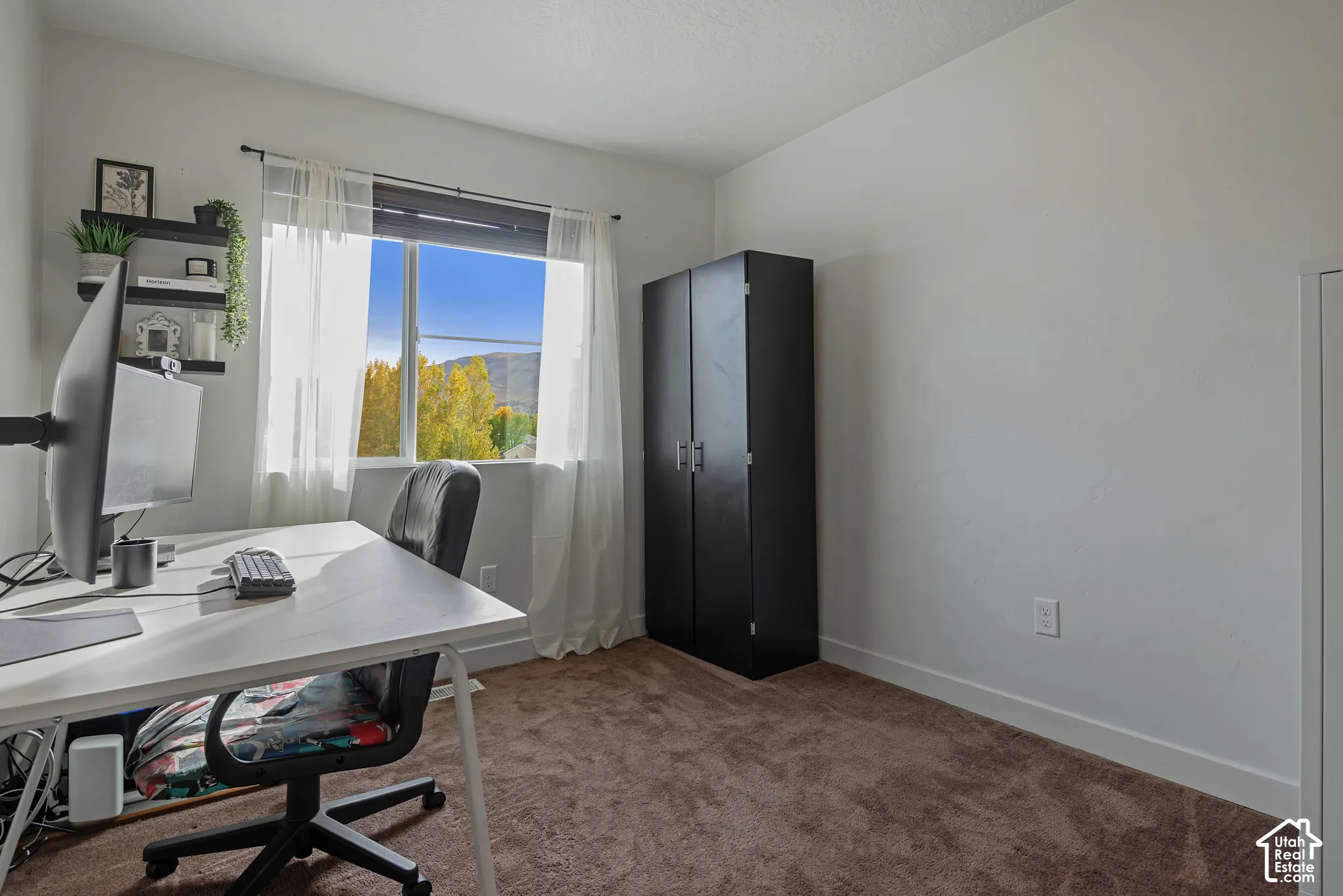 Interior room featuring wall-to-wall carpeting and a window providing natural light and mountainous scenery