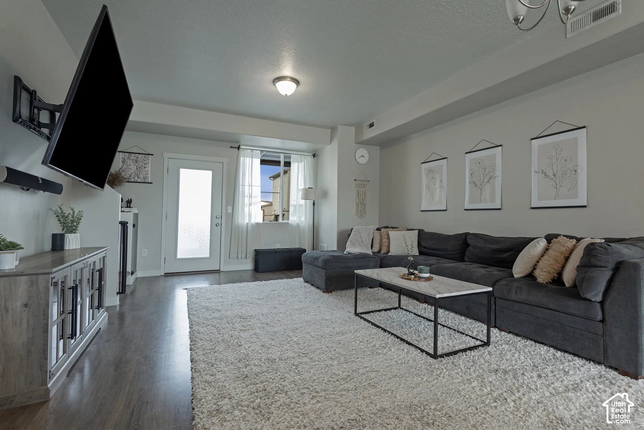 Interior space featuring wood-finish flooring, a recessed ceiling, a multi-light flush mount fixture, and an exterior door with a glass insert