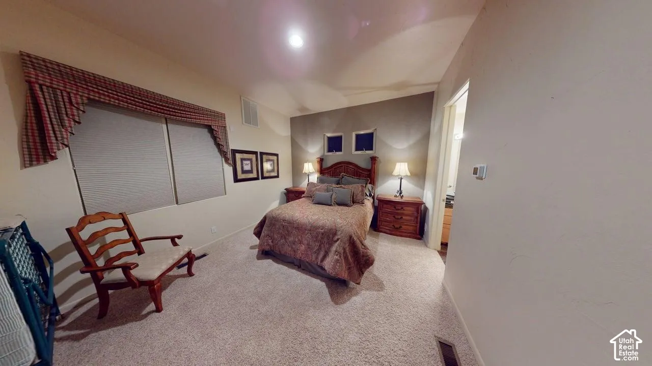 Neutral-toned room featuring high-nap carpeting, a dedicated accent wall, and dual transom windows