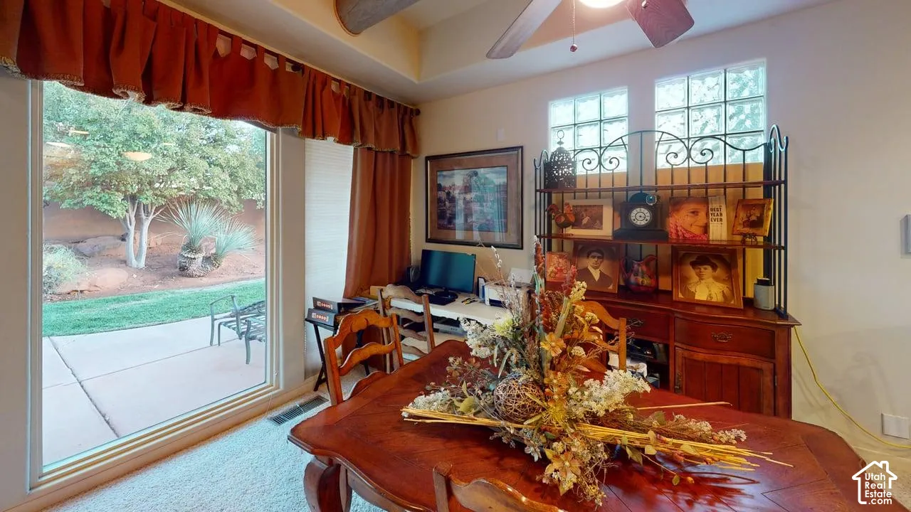 Room featuring a vaulted ceiling with exposed wooden beam, glass block clerestory windows, and a sliding glass door opening to an exterior concrete patio