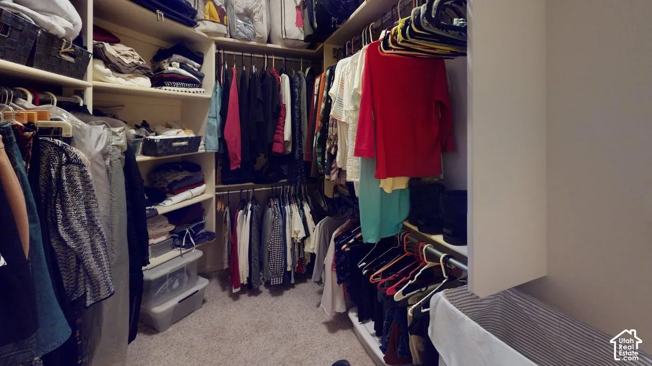 Walk-in closet featuring multi-tiered hanging rods and built-in shelving