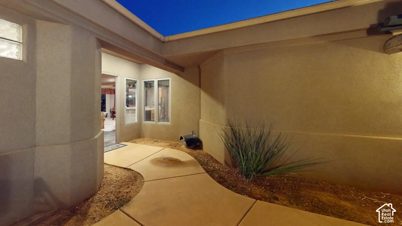 Stucco exterior featuring a curved walkway, multi-pane windows, and a glass block accent window