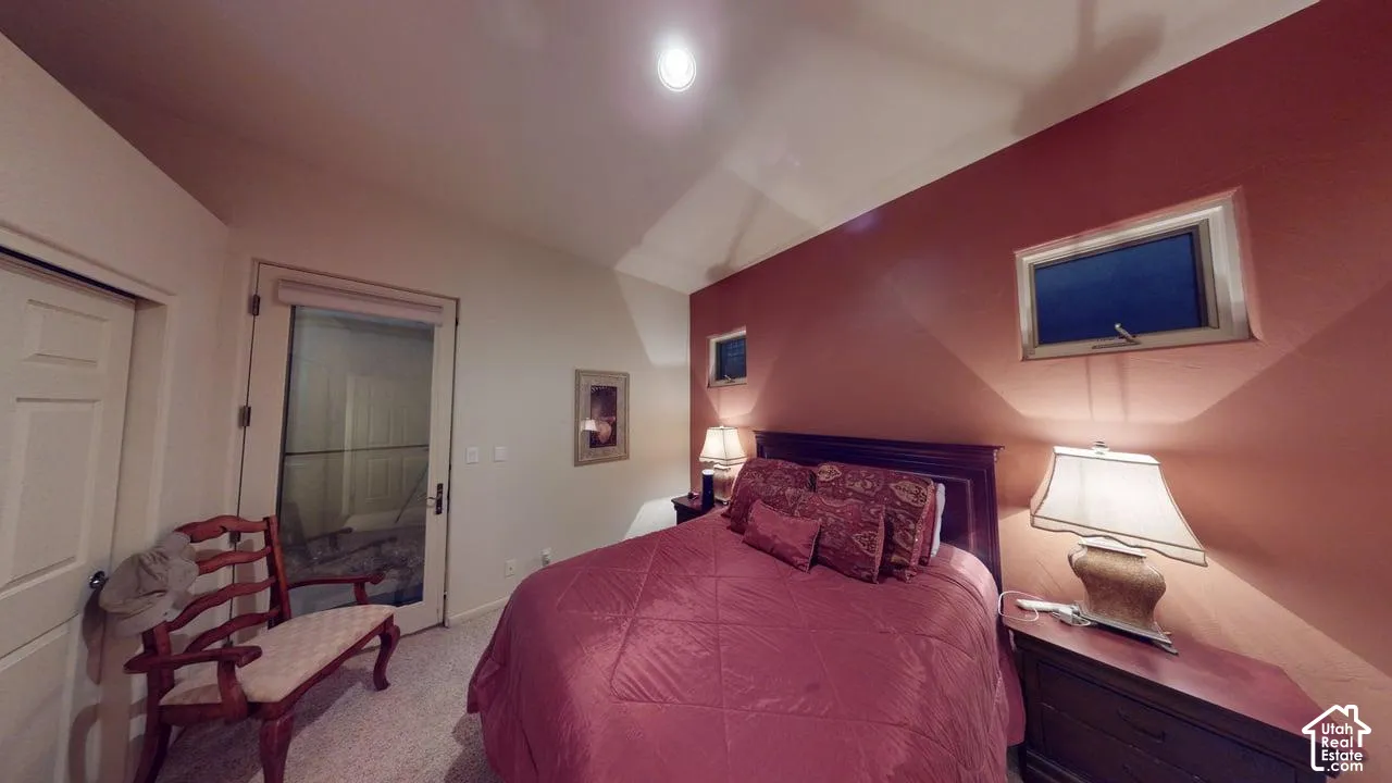 Vaulted ceilings, accent wall, recessed lighting, and glass-panel door