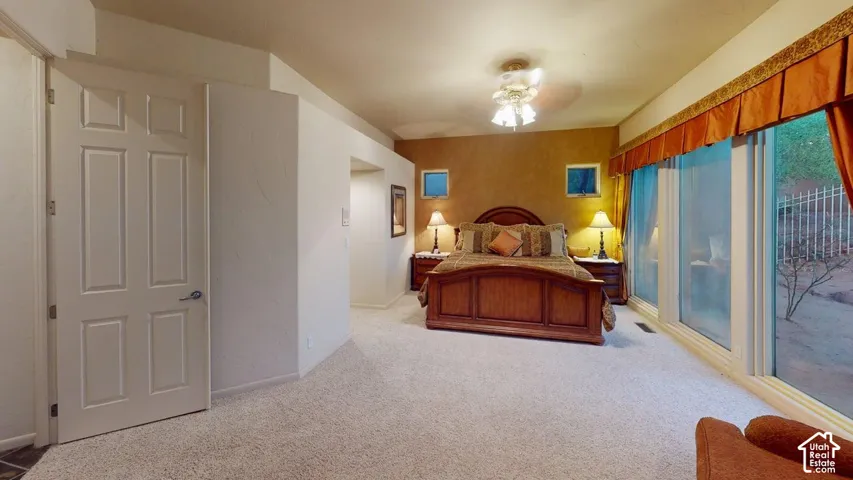 Expansive room featuring wall-to-wall carpeting, floor-to-ceiling windows, a ceiling-mounted light fixture, and textured wall accents