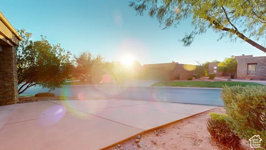 Concrete driveway, masonry exterior wall, native landscaping, and paved street access