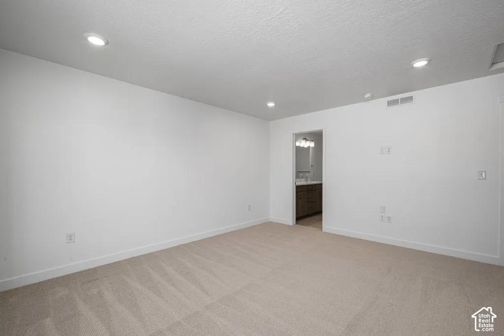 Neutral interior featuring recessed lighting, textured ceilings, and wall-to-wall carpeting