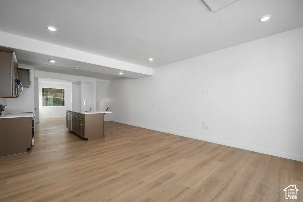 Open-concept interior featuring wood-finish flooring, recessed lighting, and a kitchen island with a light-toned countertop