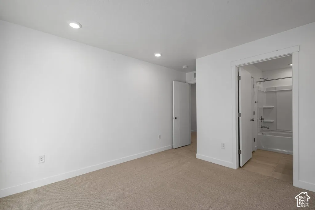 Neutral-toned wall-to-wall carpeting, recessed ceiling lighting, and solid-core interior doors