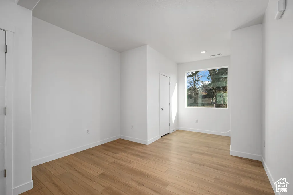 Neutral-toned room featuring wood-finish flooring, a large picture window, and recessed ceiling lighting