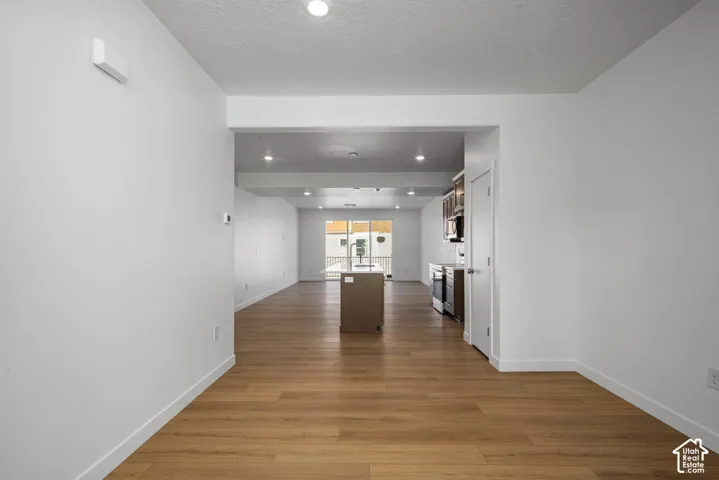 Open interior space featuring wood-finish flooring, recessed lighting, and a central kitchen island