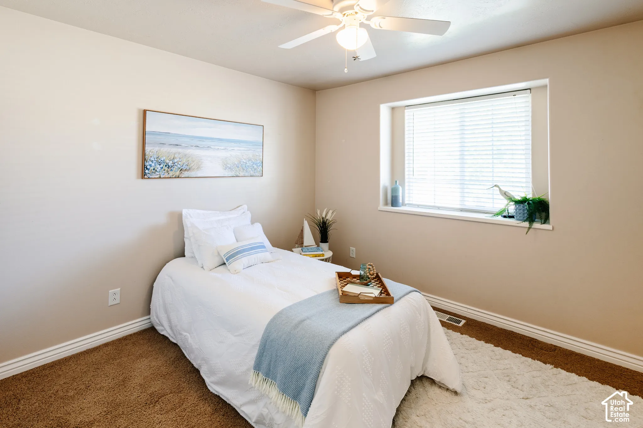 Neutral-toned walls, carpeted flooring, white ceiling fan with light fixture, and window with horizontal blinds