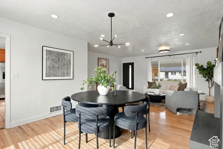 Light-filled interior featuring wood-finish flooring, a modern multi-arm chandelier, recessed lighting, and a neutral color palette