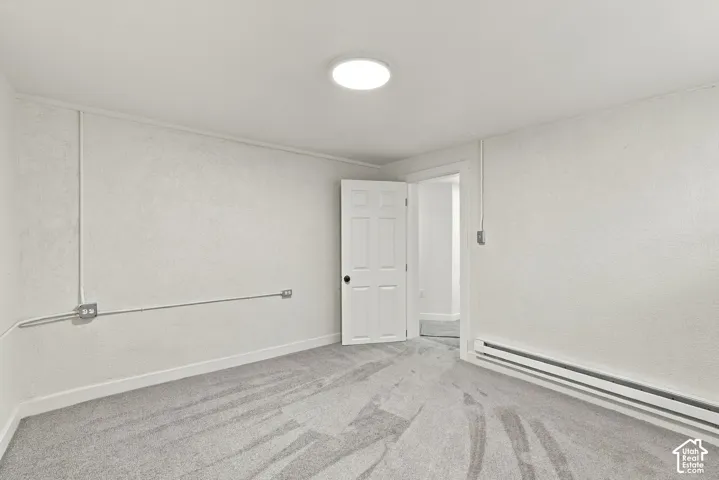 Interior space featuring wall-to-wall carpeting, textured wall finish, six-panel door, and flush-mount ceiling lighting