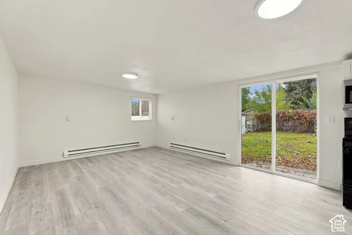 Neutral-toned wood-finish flooring, sliding glass door, flush-mount ceiling lighting, and clean-finish walls