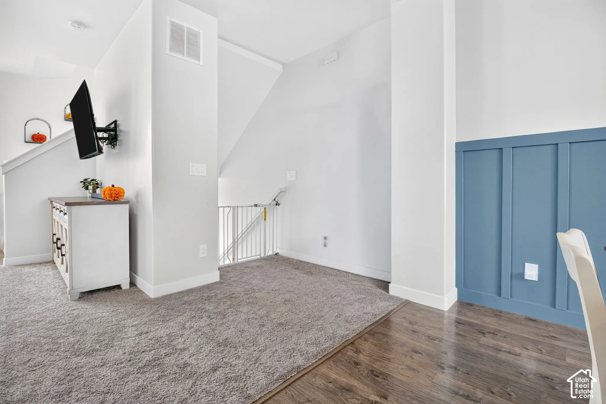 Interior space featuring wall-to-wall carpeting, wood-finish flooring, and blue board-and-batten accent wall detailing