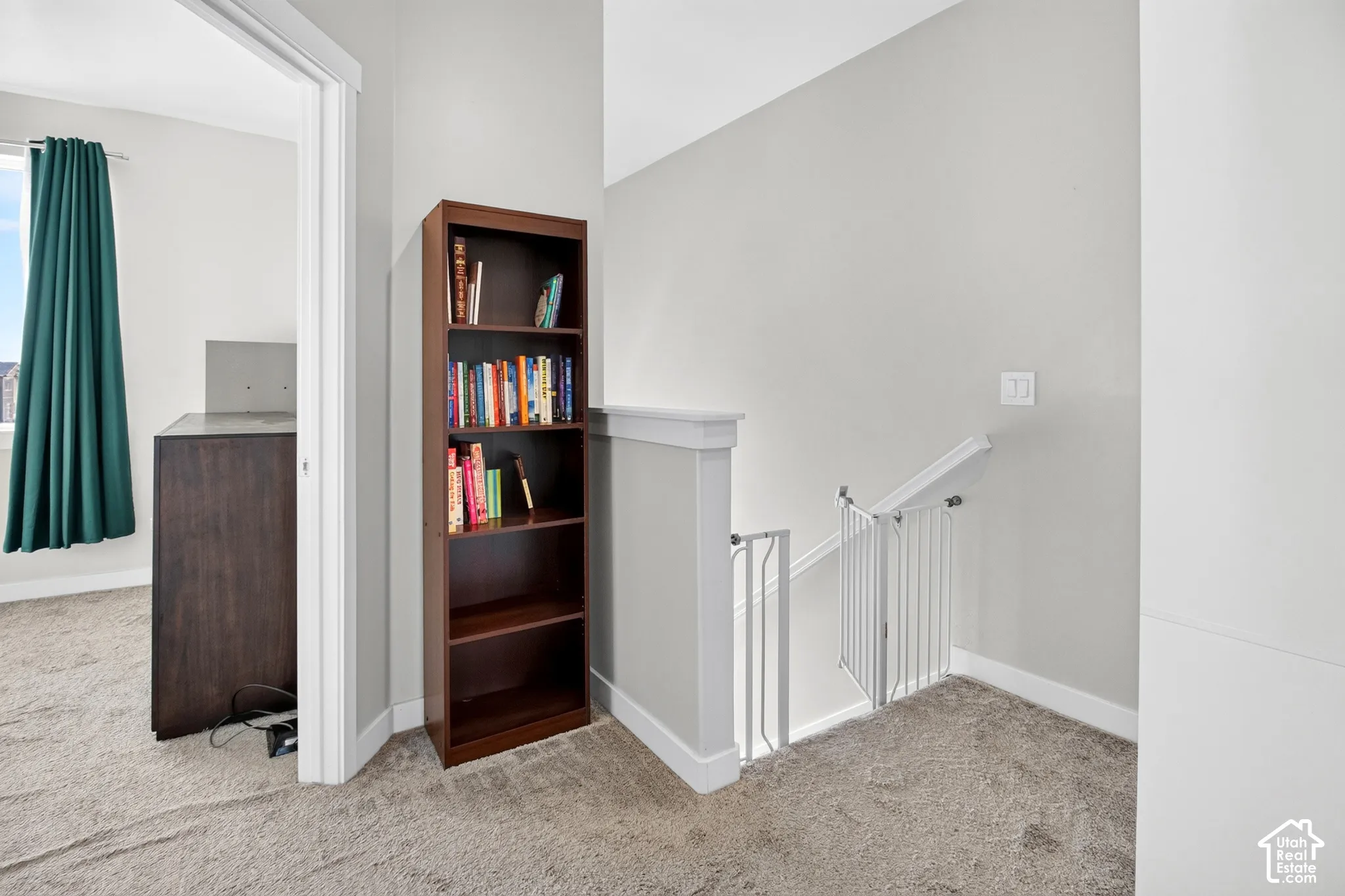 Neutral-toned interior featuring wall-to-wall carpeting, crisp white architectural trim, and a partial wall partition