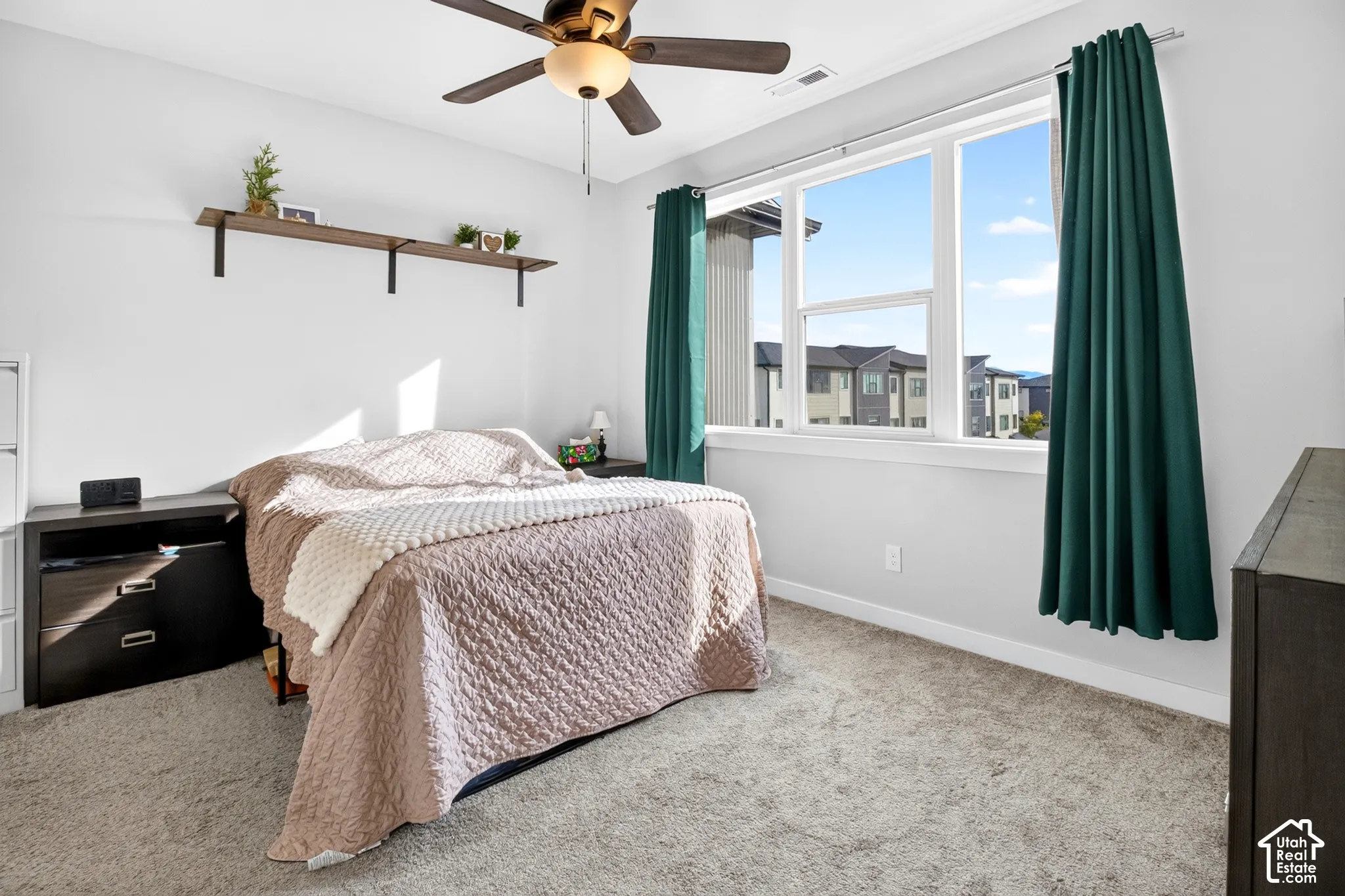 Room featuring neutral carpeting, a large multi-pane window, and a ceiling fan with integrated lighting
