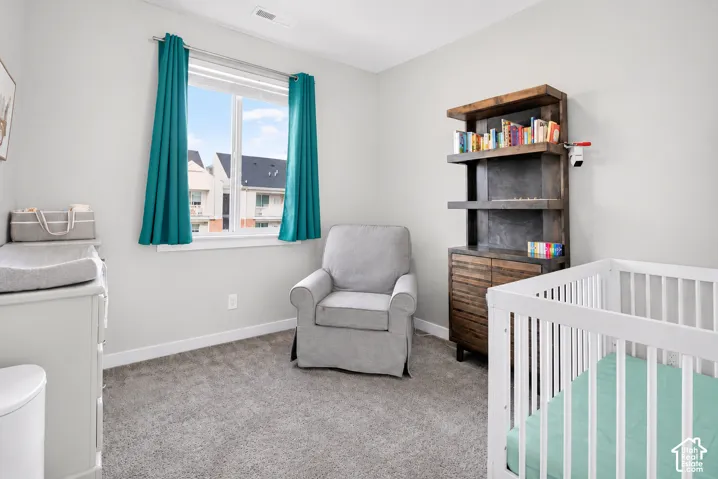 Neutral-toned room featuring wall-to-wall carpeting and a single-pane window with a white frame
