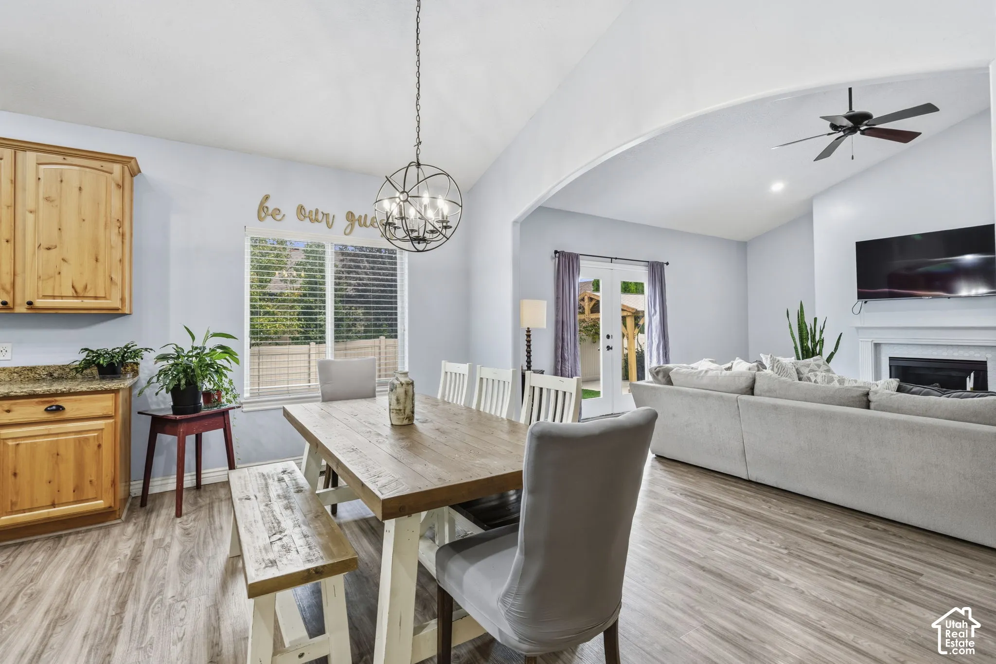 Vaulted ceilings, wood-finish flooring, built-in wooden cabinetry, recessed lighting, and a stone-surround fireplace