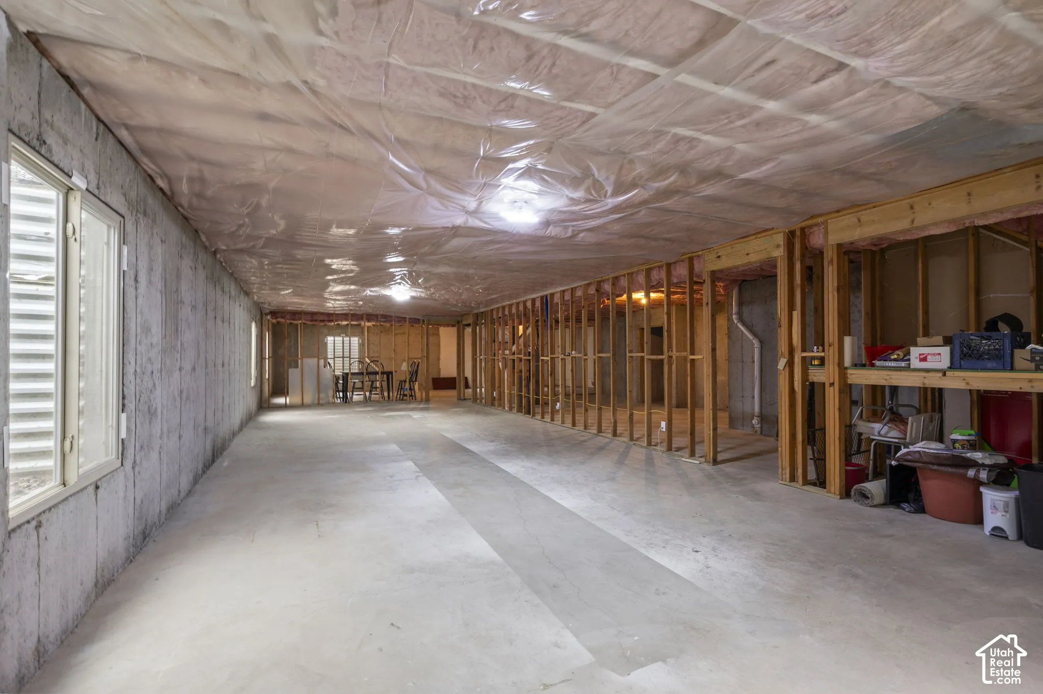 Unfinished lower level featuring 9 ft concrete foundation walls, exposed timber framing, and multiple egress windows