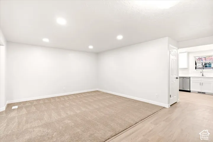 Neutral interior featuring recessed lighting, wall-to-wall carpeting, wood-finish flooring, and a multi-panel interior door