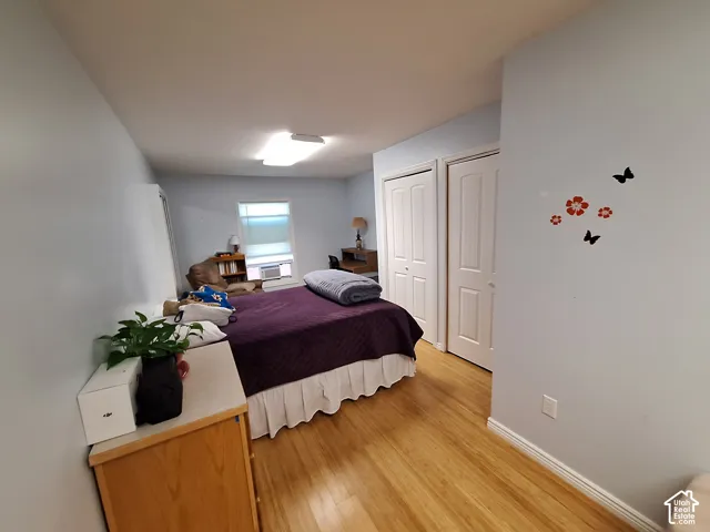 Wood-finish flooring, dual panel doors with white casing, and a rectangular window