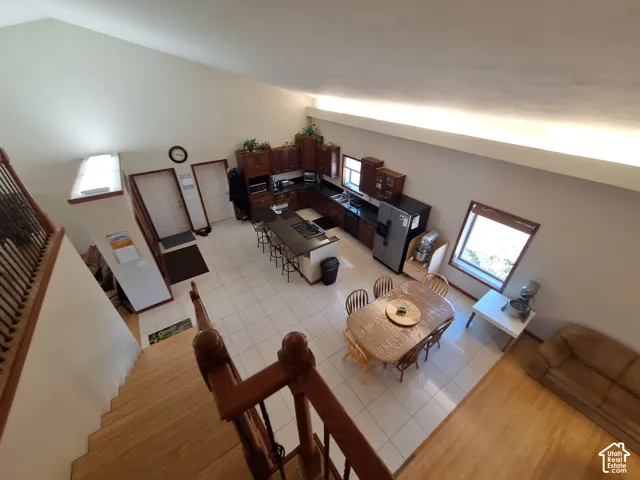 Open-concept interior featuring vaulted ceilings, tile flooring, built-in cabinetry, and kitchen island.
