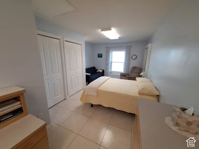 Neutral-toned tile flooring, dual closets with paneled doors, and a double-hung window