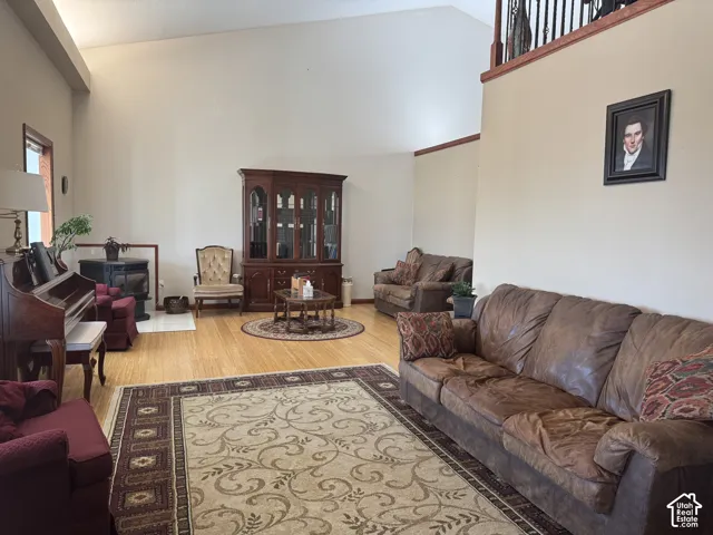 Vaulted ceilings, wood-finish flooring, metal spindle staircase railing, and a free-standing hearth